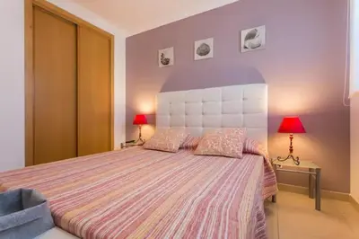 a bedroom with a large bed with two lamps at Apartamento sobre a praia in Olhos de Água