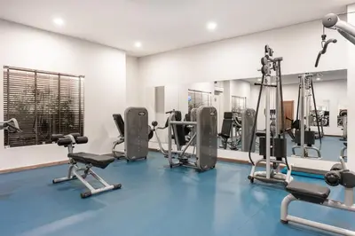 a gym with several tread machines and a mirror at 3HB Guarana - All Inclusive in Albufeira