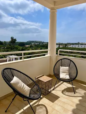 two chairs sitting on a balcony with a view at Casa Alves - Villa with private heated swimming pool in Olhos de Água