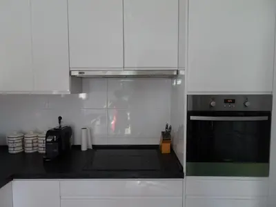 a kitchen with white cabinets and a stove top oven at Vilamoura Fantástica Moradia com Piscina Privada in Vilamoura