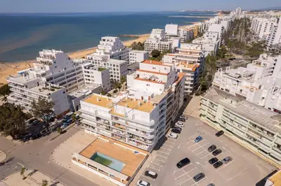 an aerial view of a city with buildings and the ocean at Centralgarve - 1 Bedroom Apartment Near the Beach in Quarteira - Anglo Atlântico in Quarteira