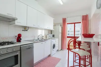 a kitchen with white cabinets and a sink and a dishwasher at Centralgarve - 1 Bedroom Apartment Near the Beach in Quarteira - Anglo Atlântico in Quarteira