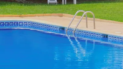 a blue swimming pool with a stairway in it at Praia Eulália with pool and 5 minutes from the beach in Albufeira