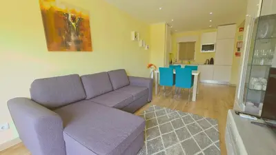a living room with a purple couch and a kitchen at Praia Eulália with pool and 5 minutes from the beach in Albufeira