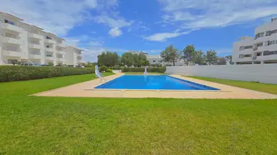 a swimming pool in the middle of a grassy yard at Praia Eulália with pool and 5 minutes from the beach in Albufeira