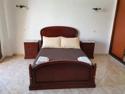 a bed with a wooden headboard in a room at Algarve Villa Albufeira Altos dos Caliços in Albufeira