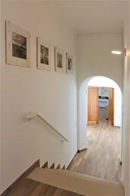 a hallway with stairs and pictures on the wall at Villa Namora - Private Swimming pool & Hot Jacuzzi in Albufeira