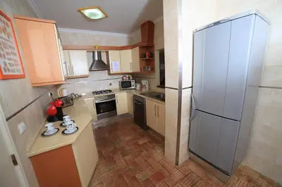 a small kitchen with a large refrigerator in it at Casa Coral in Albufeira