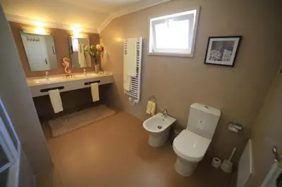 a bathroom with a toilet and a sink and a mirror at Casa Coral in Albufeira