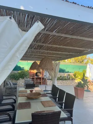 a patio with a table and chairs under awning at Casa Coral in Albufeira