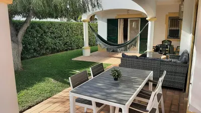 a patio with a table and chairs and a hammock at Villa White Sands - Private Oasis, Heated Pool, Beaches & Strip Nearby in Albufeira