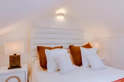 a bedroom with a white bed with brown pillows at Gold Suites - Luxurious apartment - Sea view in Vilamoura