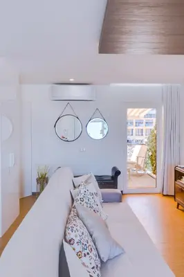 a living room with a white couch with pillows at Gold Suites - Luxurious apartment - Sea view in Vilamoura