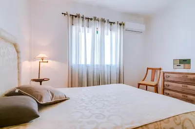 a bedroom with a bed and a dresser and a window at Mango Apartment - Faro city center in Faro