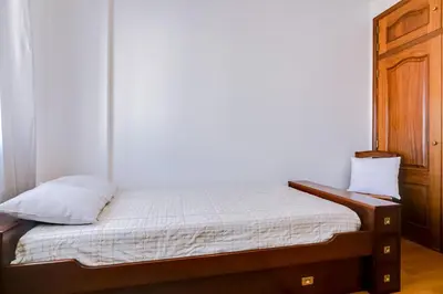 a small bed in a room with a wooden cabinet at Mango Apartment - Faro city center in Faro