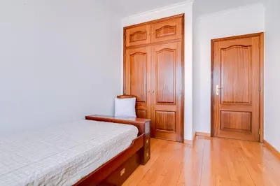 a bedroom with a bed and a wooden door at Mango Apartment - Faro city center in Faro
