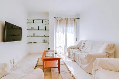 a white living room with a couch and a table at Mango Apartment - Faro city center in Faro