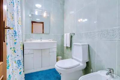 a bathroom with a white toilet and a sink at Mango Apartment - Faro city center in Faro