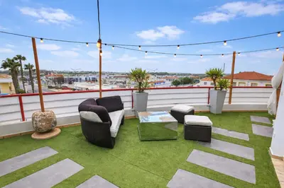 a patio with a table and chairs on a balcony at Penthouse with Private Rooftop & Seaview in Guia