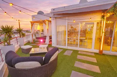 a patio with a couch and chairs on the grass at Penthouse with Private Rooftop & Seaview in Guia