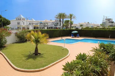 a swimming pool with a palm tree in a yard at Recanto da Galé by Umbral in Albufeira