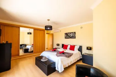 a bedroom with a large bed with red pillows at Villa Laguna by Algarve Vacation in Albufeira