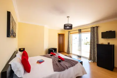 a bedroom with a bed with red pillows on it at Villa Laguna by Algarve Vacation in Albufeira