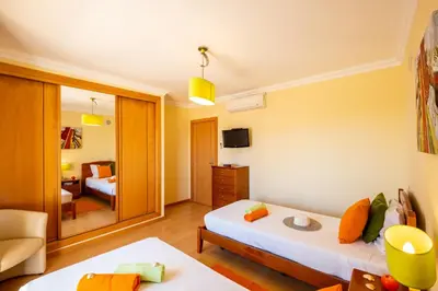 a room with two beds and a living room at Villa Laguna by Algarve Vacation in Albufeira