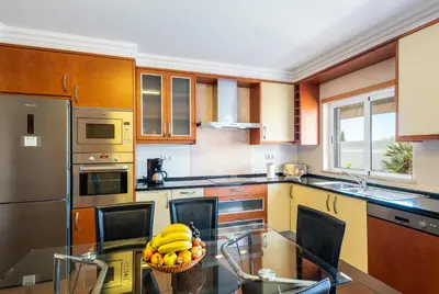 a kitchen with a glass table with a basket of bananas at Villa Laguna by Algarve Vacation in Albufeira
