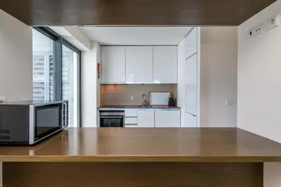 a kitchen with white cabinets and a microwave at BmyGuest - Cavalo Preto Beach Apartment in Loulé