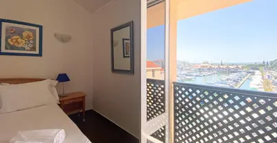 a bedroom with a bed and a balcony with a view at Penthouse Duplex Marina Plaza T1 HsR Marina Vilamoura in Vilamoura