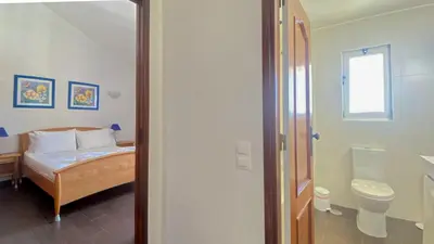 a bedroom with a bed and a toilet and a window at Penthouse Duplex Marina Plaza T1 HsR Marina Vilamoura in Vilamoura