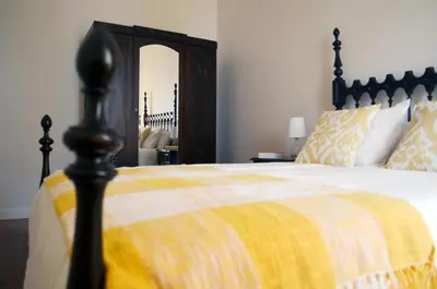 a bedroom with a bed with a yellow and white blanket at Casa aOrta in Faro