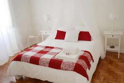a bedroom with a large white bed with red pillows at Casa aOrta in Faro