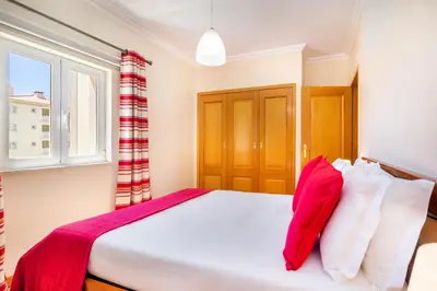 a bedroom with a large bed with a window at WHome | Vilamoura Family Apartment in Quarteira