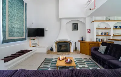a living room with a couch and a fireplace at Villa Lageado by IntiHolidays in Albufeira