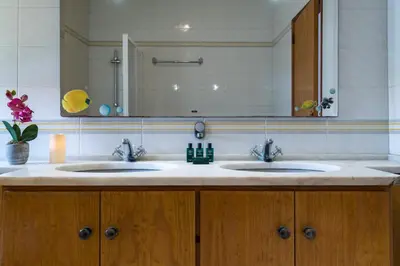a bathroom with two sinks and a large mirror at Villa Lageado by IntiHolidays in Albufeira