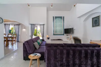 a living room with a purple couch and a table at Villa Lageado by IntiHolidays in Albufeira