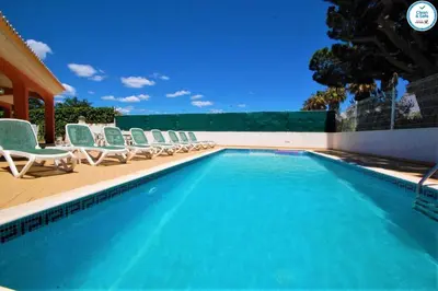 a swimming pool with lounge chairs and a swimming pool at Villa Mikael - Free Wi-Fi - Aircon - Private Pool by bedzy in Albufeira