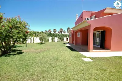 a house with a grass yard next to a building at Villa Mikael - Free Wi-Fi - Aircon - Private Pool by bedzy in Albufeira