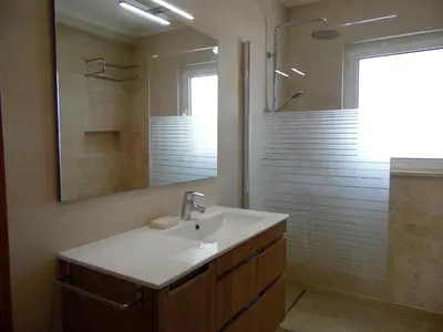 a bathroom with a sink and a shower with a mirror at Paradise in Olhos D'água Beach in Albufeira