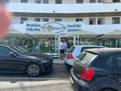 a group of parked cars parked in front of a building at Bellavista Modern Comfort, 3 Balcony, Family Apartment with Wi-Fi in Albufeira