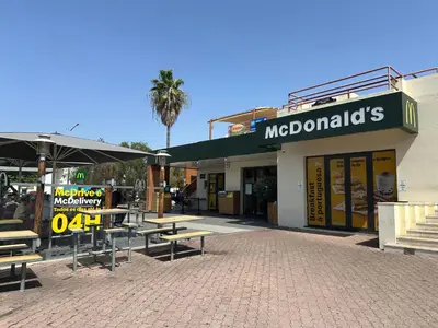 a restaurant with tables and umbrellas in front of a building at Bellavista Modern Comfort, 3 Balcony, Family Apartment with Wi-Fi in Albufeira