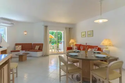a living room with a table and chairs at FLH Balaia Village Apartment with Pool I in Olhos de Água