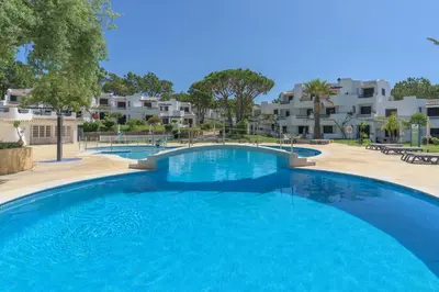 a large blue swimming pool with buildings in the background at FLH Balaia Village Apartment with Pool I in Olhos de Água