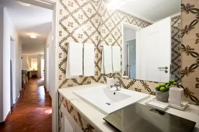 a bathroom with a sink and a mirror at Albufeira Club 98 - O refúgio perfeito in Albufeira