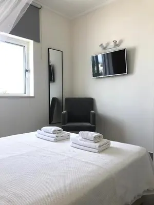 a white room with a bed and a chair at Casa Netos in Galé