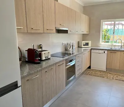 a kitchen with white appliances and wooden cabinets at Casa Netos in Galé