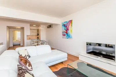 a living room with a white couch and a tv at Onde a Marina é Casa T2 HsR Vilamarina in Vilamoura