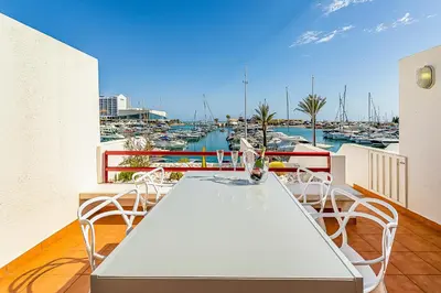 a white table and chairs on a balcony with a marina at Onde a Marina é Casa T2 HsR Vilamarina in Vilamoura